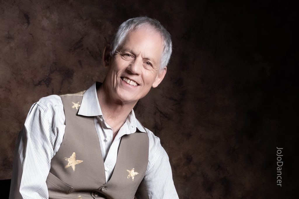 Rudi Harst smiling in a relaxed portrait