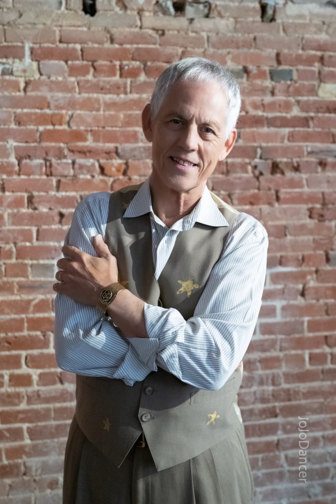 Rudi Harst in a reflective brick-wall portrait