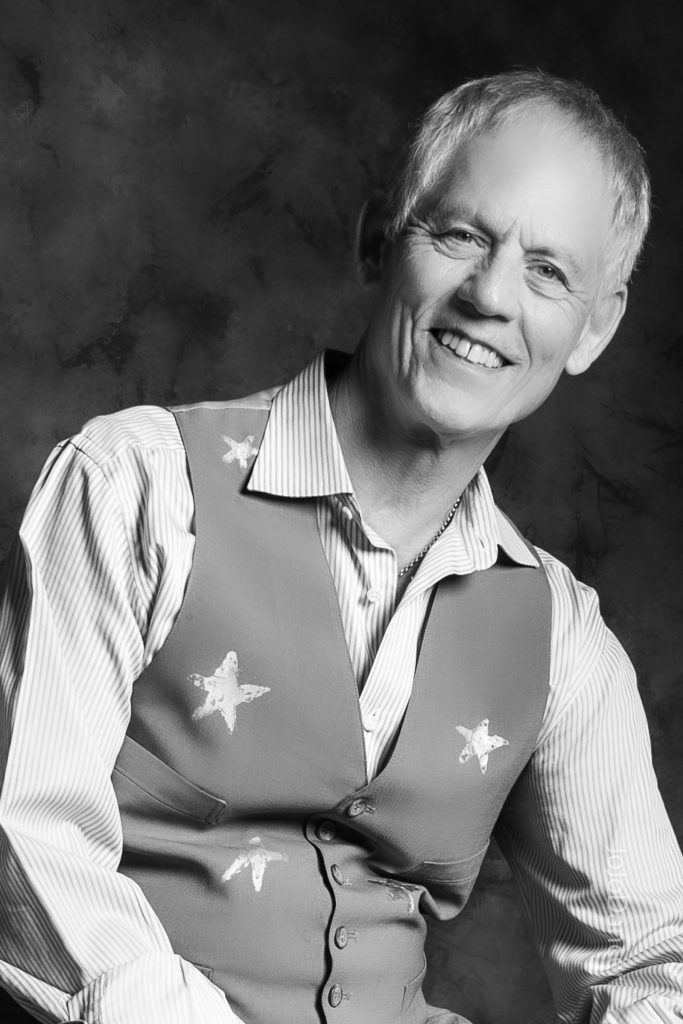 Rudi Harst laughing in a close studio portrait