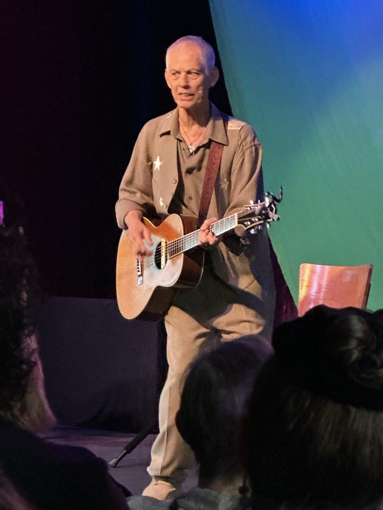 Rudi Harst playing guitar during a live show