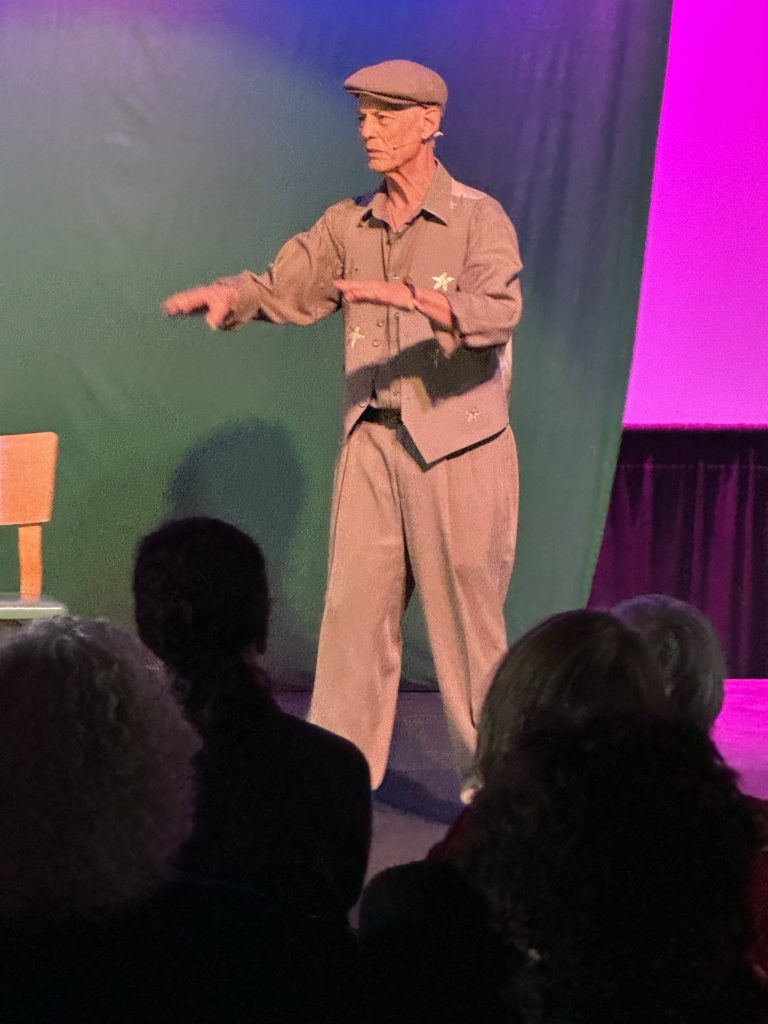 Rudi Harst addressing an audience from the stage