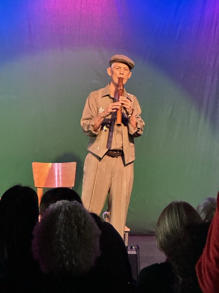 Rudi Harst speaking into a microphone onstage