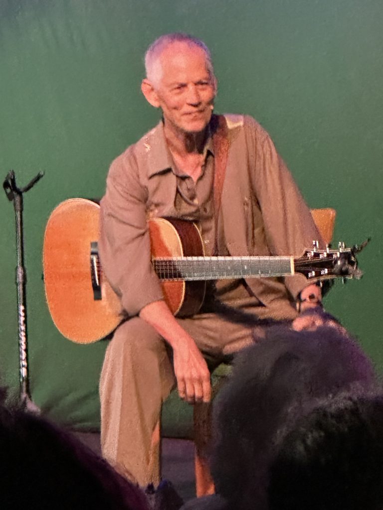 Rudi Harst performing with acoustic guitar