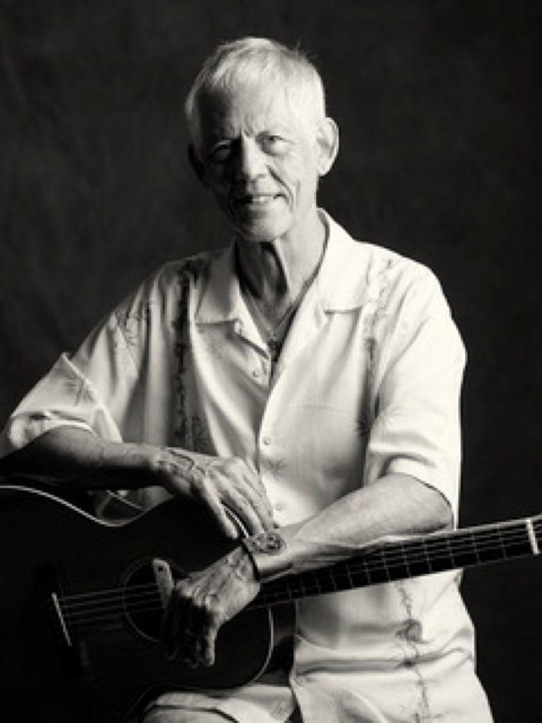 Rudi Harst playing guitar in a portrait by Ramin Samandari