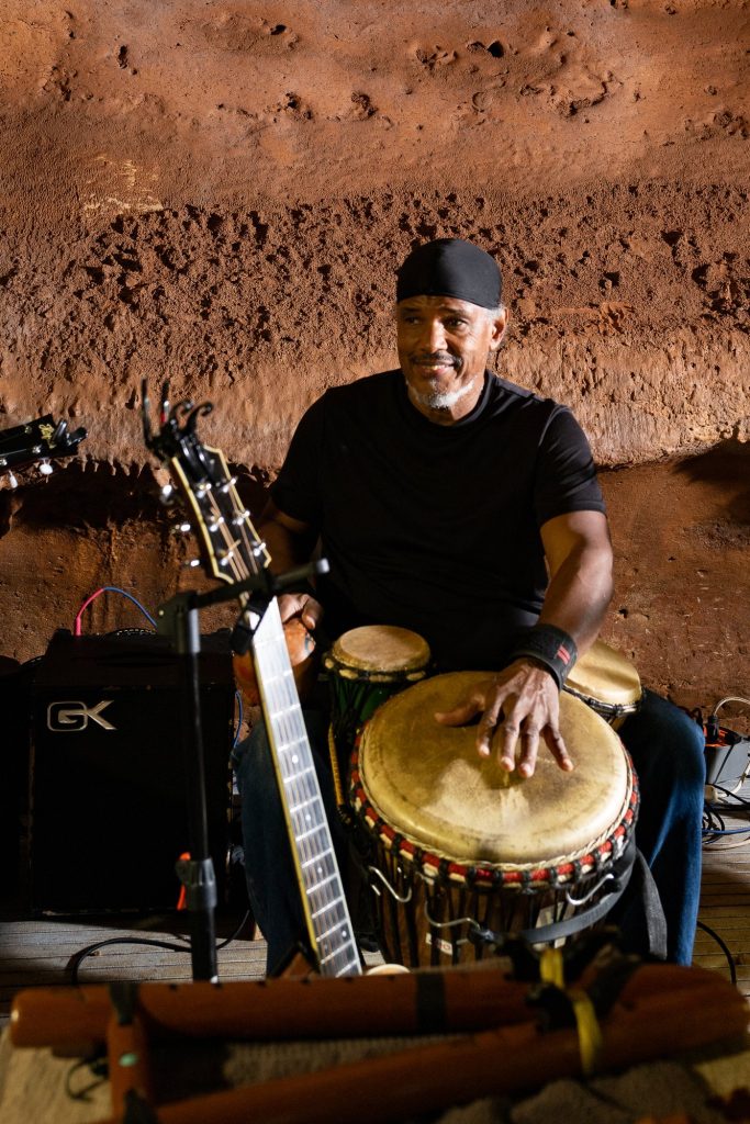 A percussionist in a black shirt playing a hand drum