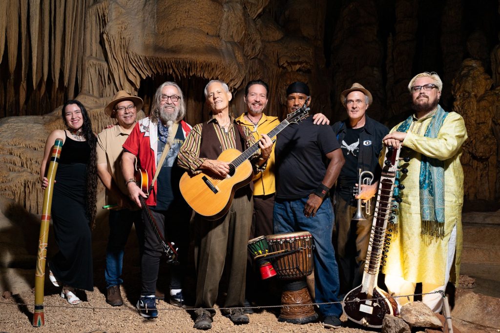 Wide portrait of Rudi Harst and seven fellow musicians in the cave