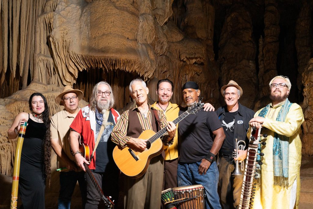 Wide group portrait with Rudi Harst holding his guitar at the center