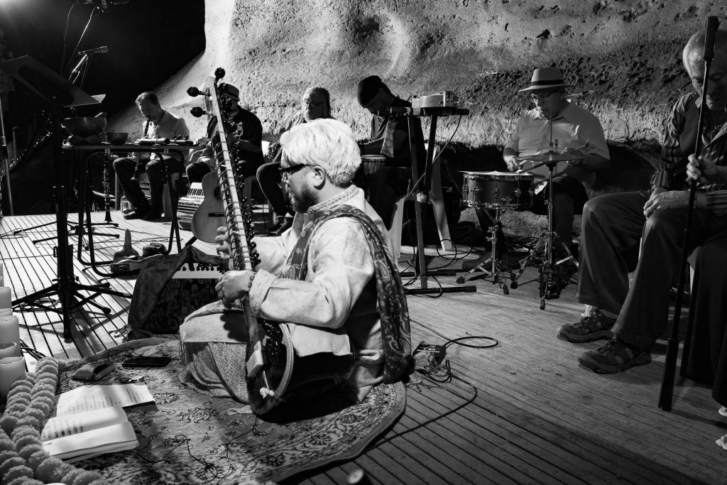 Monochrome side view of the sitar player seated in front of the ensemble