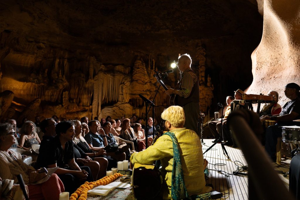 Rudi Harst performing toward the audience with the sitar player in the foreground