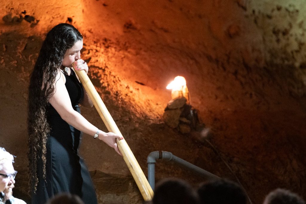 Closer view of a musician playing a long wooden wind instrument